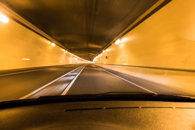 Automobile in tunnel with illuminated lamps