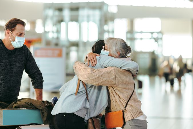 Older woman welcoming her daughter arriving at airport after pandemic