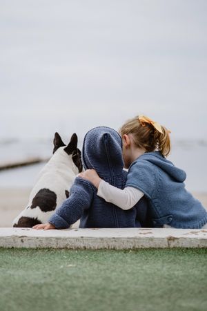 Kids hugging dog on beach