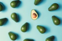 Whole avocado pattern on a pastel blue background