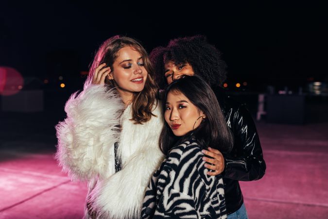Multi-ethnic group of women in faux furs posing for the camera