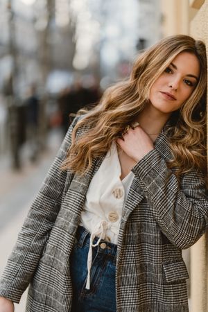 Woman leaning on wall on street