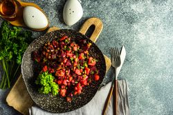 Top view of colorful beetroot salad on grey kitchen counter with copy space