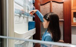 Sad girl taking an egg from the empty fridge