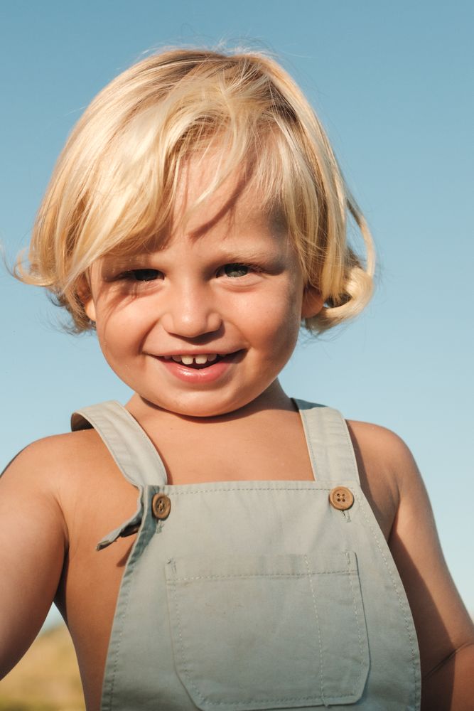 Happy little boy against blue sky
