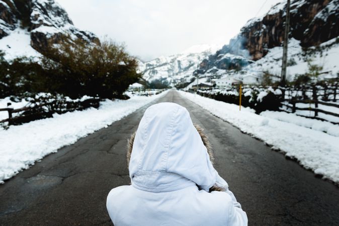 Anonymous person standing on road in countryside