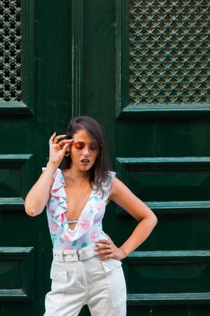 Confident stylish woman in sunglasses standing on city street