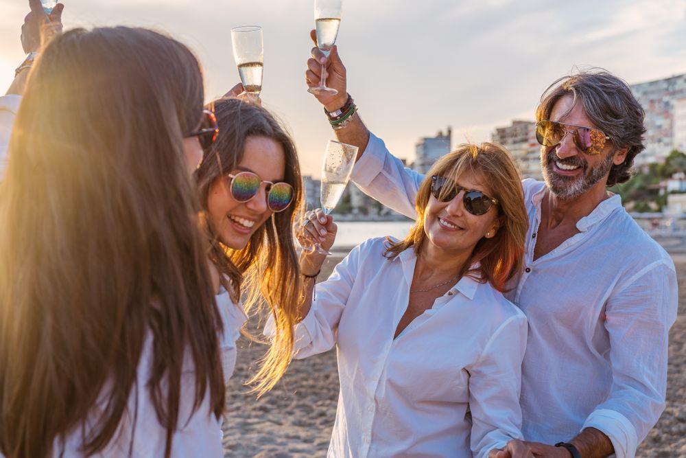 Happy family drinking wine on beach