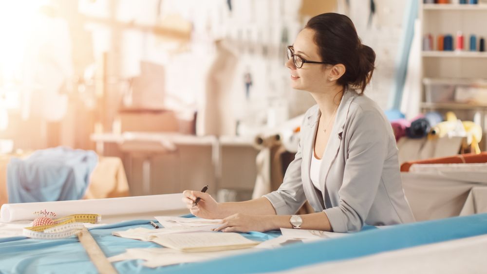 Female fashion, designer,  Sits at Her Desk and Draws Sketches.