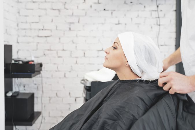 Stylist washing hair of woman