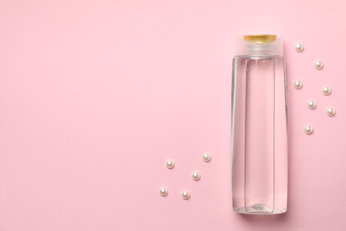 Blank shampoo bottle on pink background, space for text