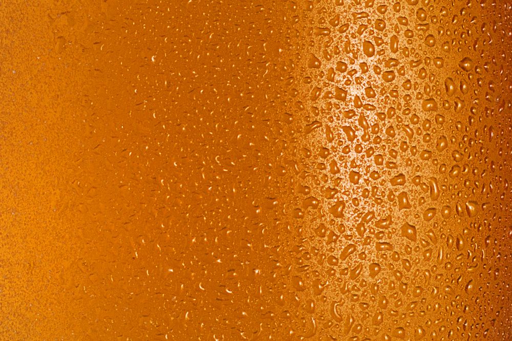 Condensation drops on glass of orange drink