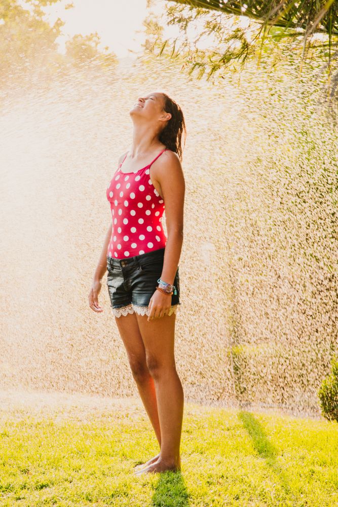 Cheerful teenager having fun with jet of water