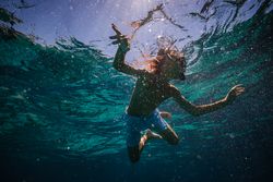 Preteen child in diving mask with snorkel swimming underwater