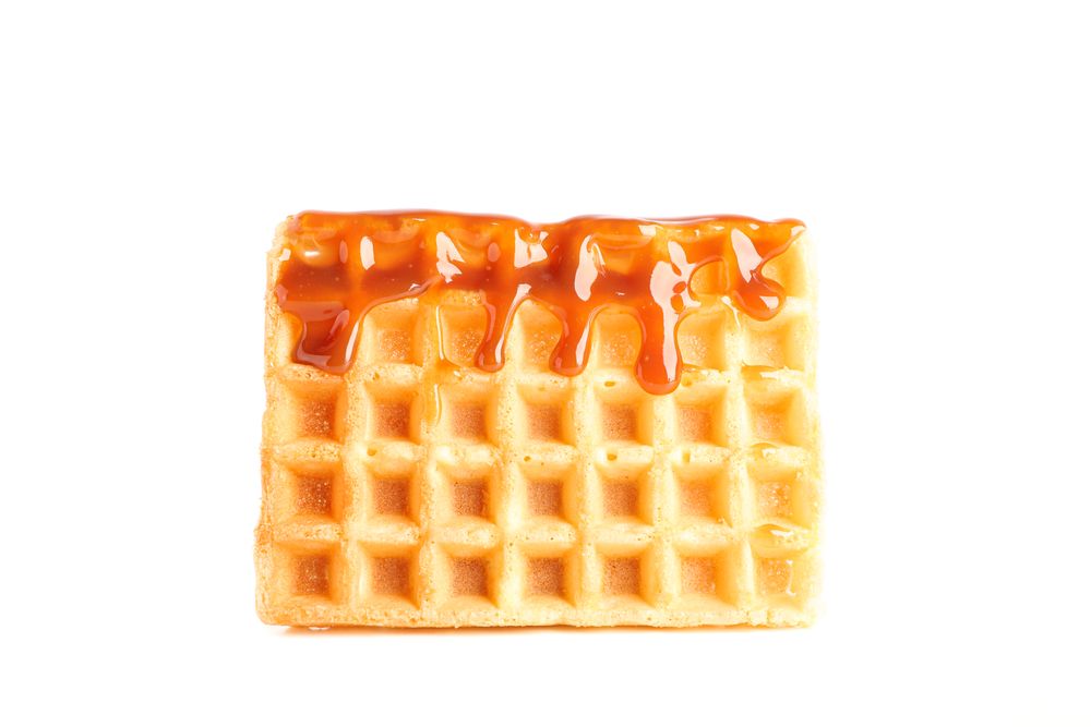Waffle under caramel topping isolated on blank background