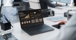 Manager Analyzing Financial Reports, Looking at a Laptop Computer Screen with Graphs and Charts