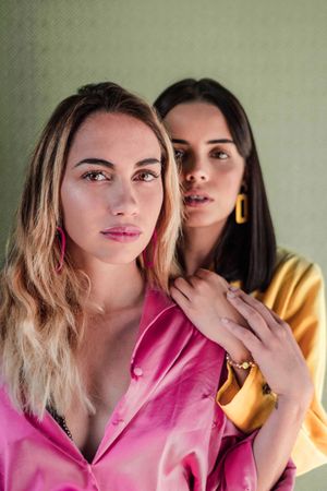 Young trendy women in bright clothes looking at camera