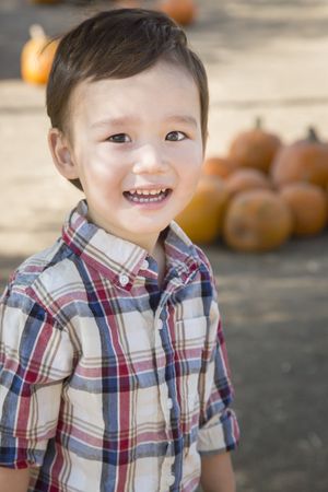 Smiling Young Boy Having Fun at the Pumpkin Patch