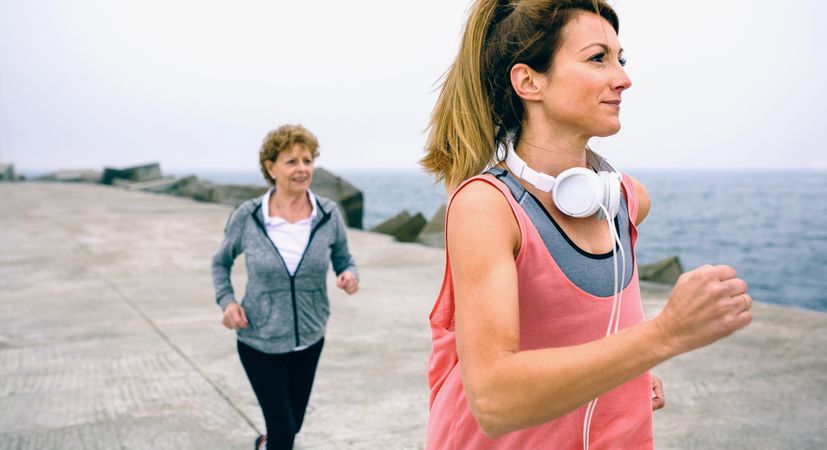 Young and mature sportswoman running
