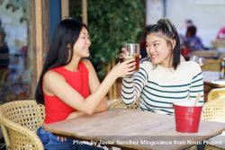 Two women sitting in restaurant patio with beverages 5RQO10