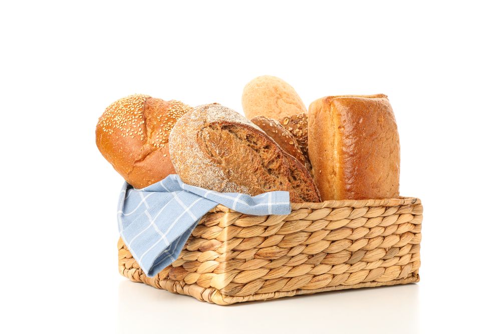 Bakery products in straw basket isolated on blank background