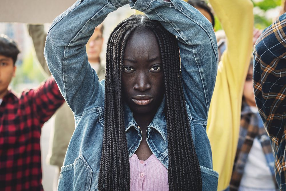 Detail on a young black woman marching during a protest