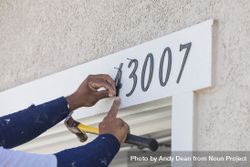 House Painter Contractor Nails Address Numbers to House Facade 0WOGKO