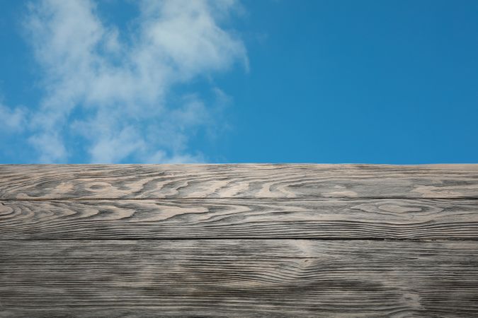 Wooden table against blue skies, space for text. Mockup