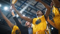 Yellow Team Basketballers Celebrating Successful Victory Over a National Basketball Club, Cheering Together with Teammates and Coaches.