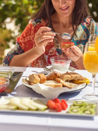 Anonymous woman eating on hotel terrace