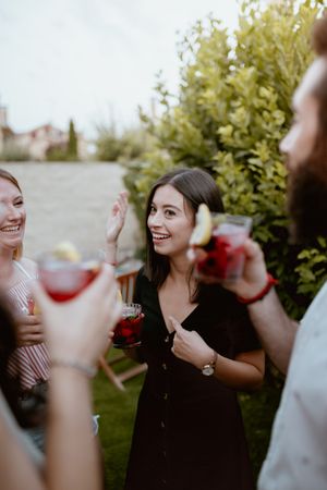 Group of cheerful friends clinking glasses at party