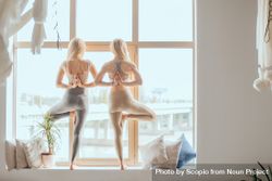 Two women doing yoga in front of window during daytime bDWqQ4