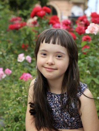 Little girl smiling while sitting in a floral garden