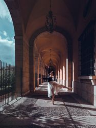Flexible ballerina performing arabesque position in archway of b