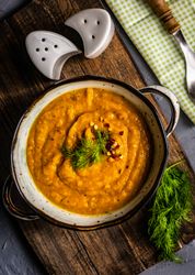 Top view of hearty pumpkin soup with chili flakes and garnish 