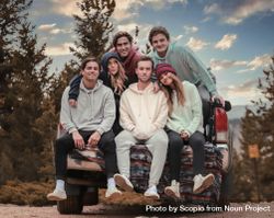 Group of young people sitting on a car in nature 4AX8Y5