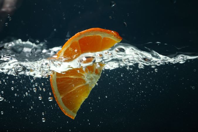 Side view of water wave on dark background with orange