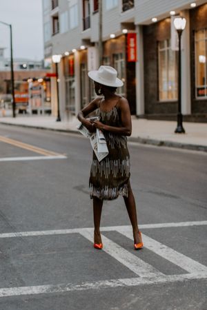 Woman in red heels standing in the street looking backwards