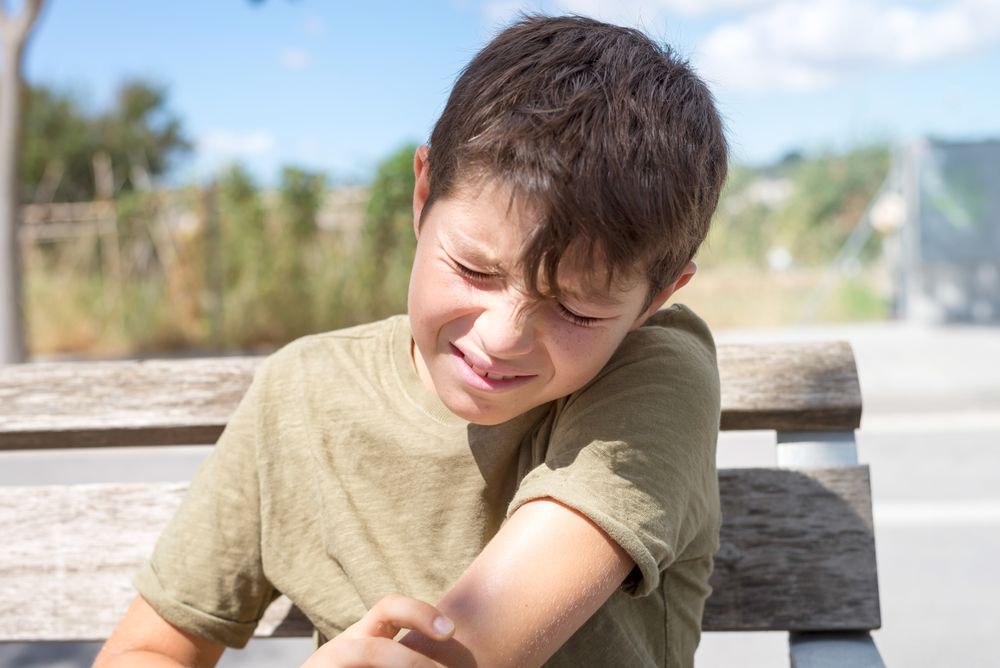 Grimacing teenager sitting on bench outside