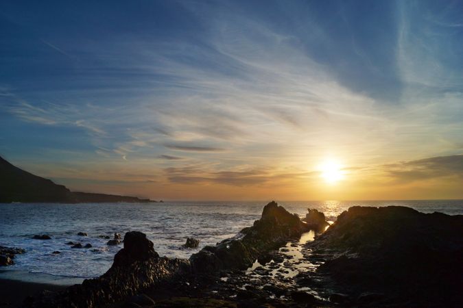 Evening landscape of ocean waves and rocky seaside