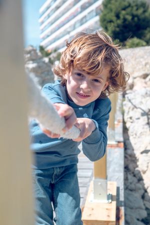 Cute boy leaning on rope