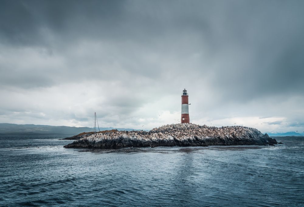 Lighthousein a small island in stormy sea on overcast day