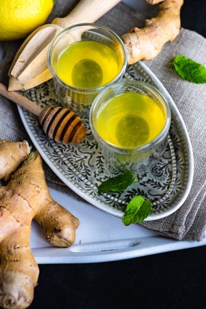 Detox shots with lemon, ginger and mint on silver tray