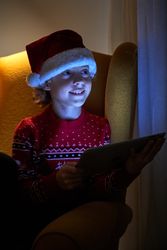Cute boy in Santa hat using tablet