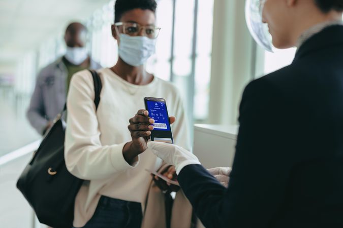 Female in pandemic with digital air ticket at airport