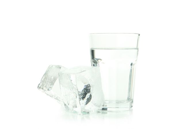 Tall glass of water pictured with large clear ice cubes