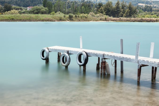 Wooden broken old pier in calm water