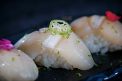 Delicious nigiri sushi with flowers on marble plate