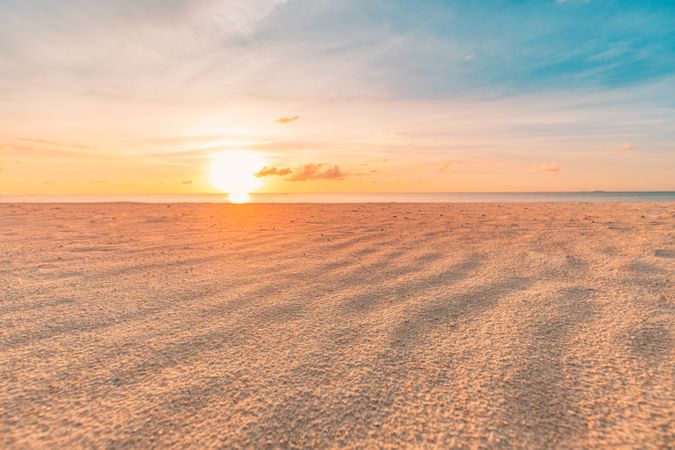 Sand on the beach as the sun sets over the ocean