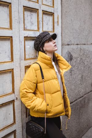 Stylish woman near shabby wall on street
